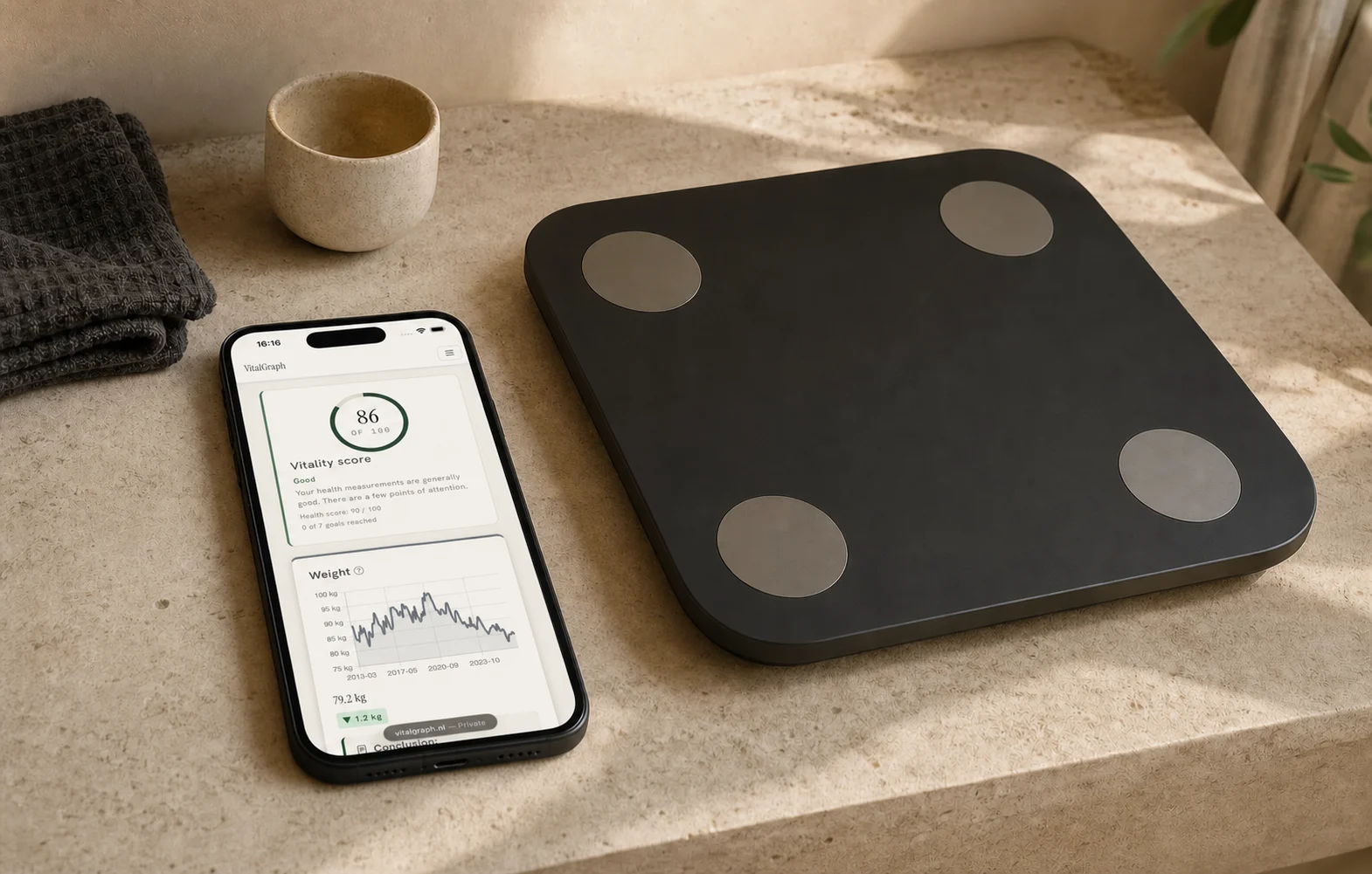 foto: VitalGraph op een telefoon naast een weegschaal